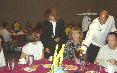 Julia answering etiquette questions at an Etiquette Luncheon Presentation
